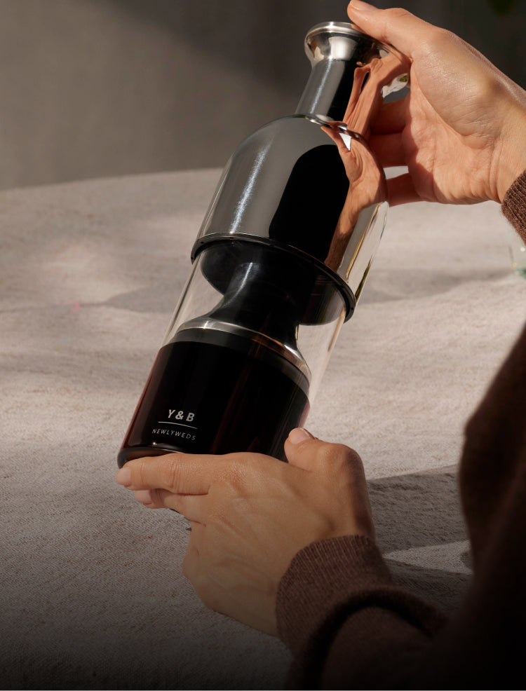 A woman displaying an eto wine decanter with engraved lettering for newlyweds