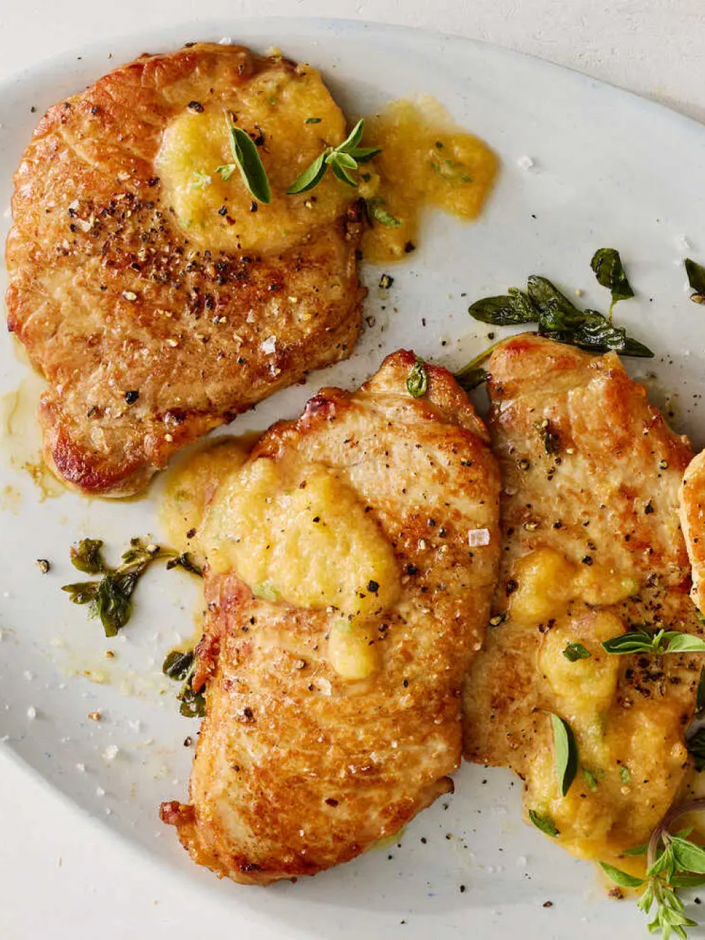 Breaded chicken cutlets with a side of mashed potatoes on a white plate.