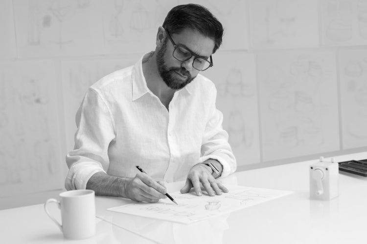 a black and white photo of eto inventor Tom Cotton sketching
