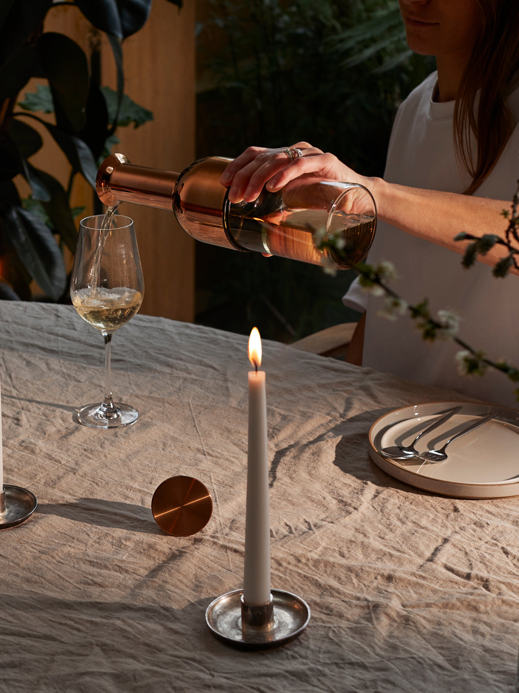 An eto wine decanter being poured by a women into a wine glass on a dining table