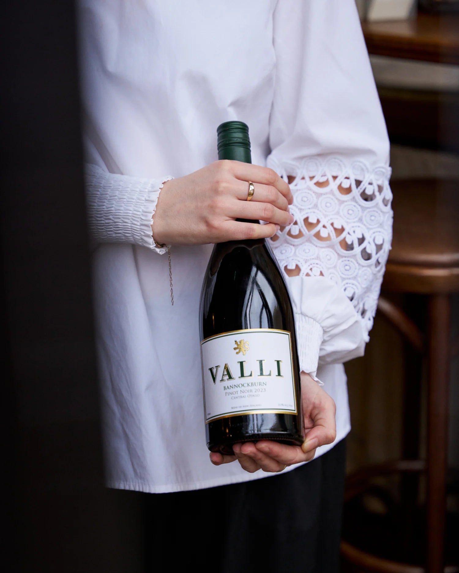 Person holding a bottle of Valli wine with a blurred background