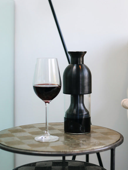 eto wine decanter in graphite steel filled with red wine on top of a side table in the living room