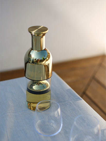 eto wine preserving decanter in gold mirror filled with white wine