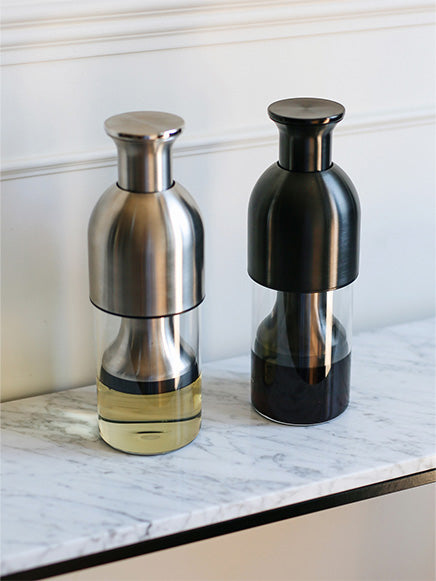 eto wine decanters in stainless satin and graphite steel finish on top of a marble counter